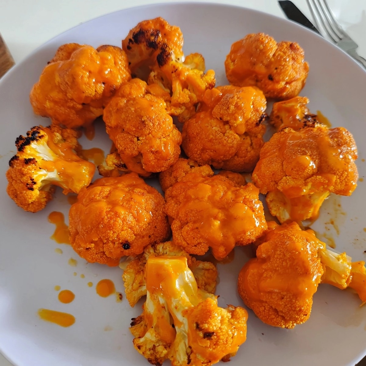 Golden Vegan Buffalo Cauliflower Wings fresh from the oven, glistening with spicy sauce.