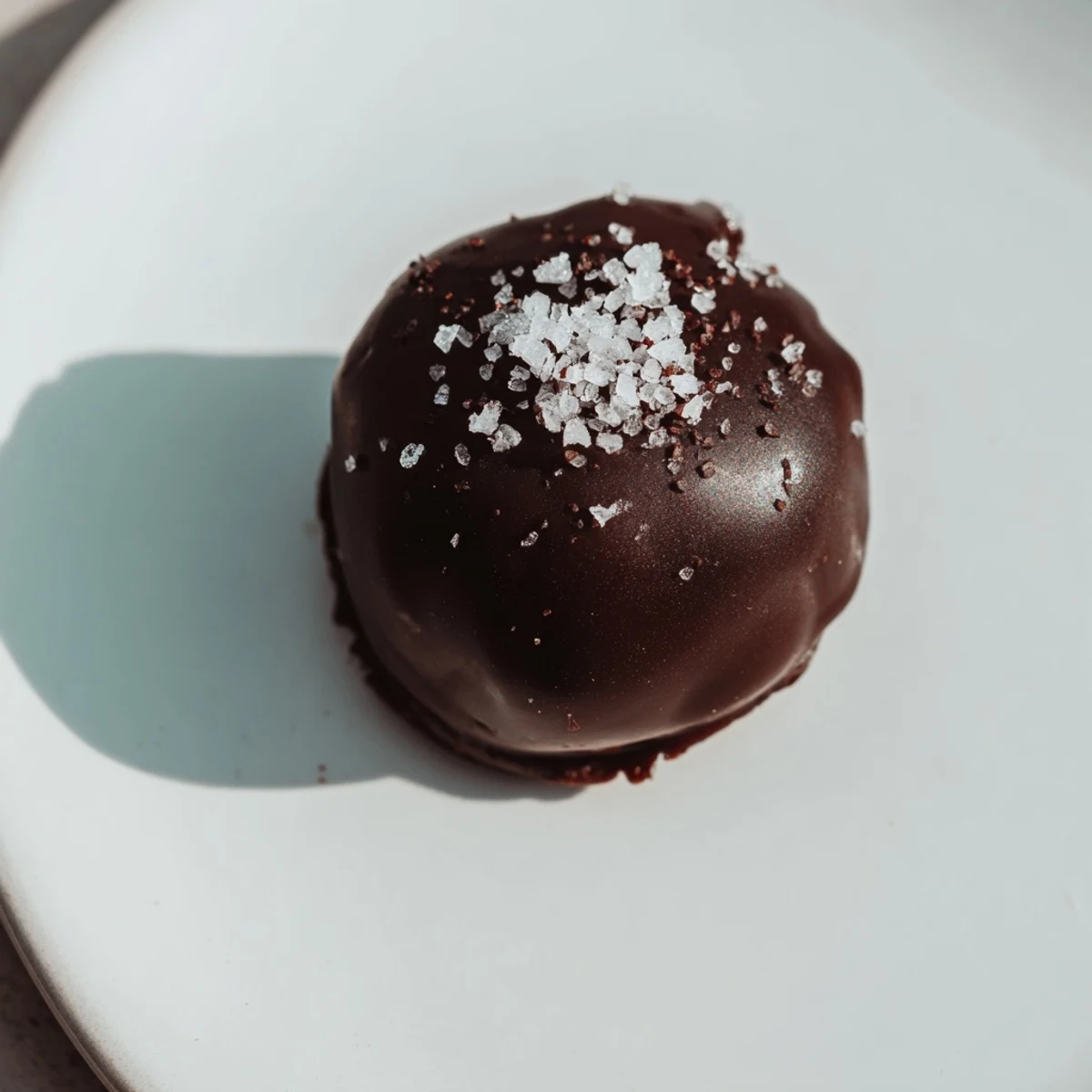 Dark chocolate truffles glistening with sea salt, a perfect treat for your next gathering.