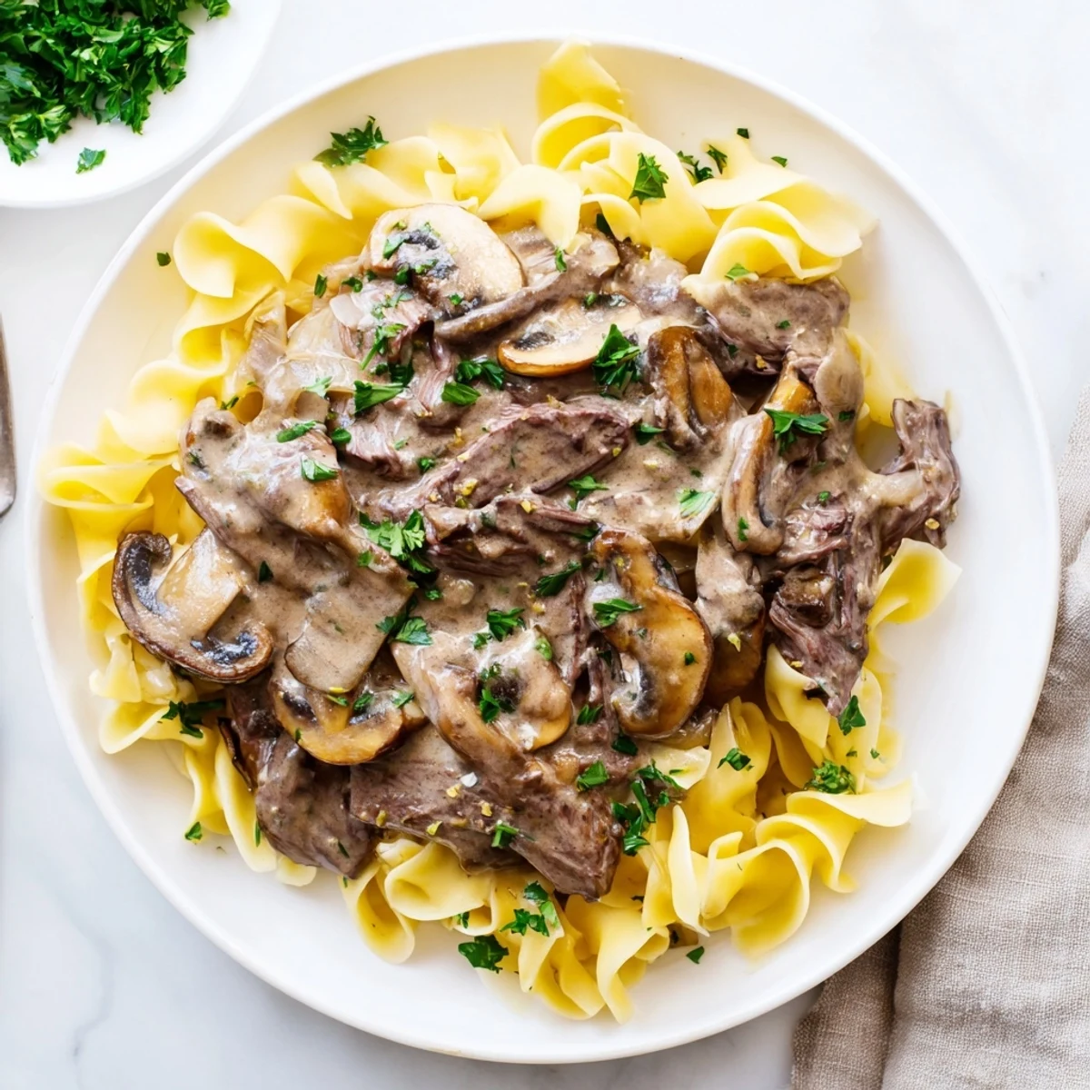 Tender beef strips in a creamy, mushroom sauce spooned over a bed of egg noodles: Rich Beef Stroganoff.