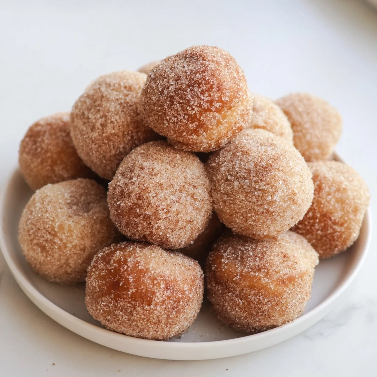 Warm, freshly fried cinnamon sugar donut holes, dusted in sweet, spiced sugar, perfect for sharing.