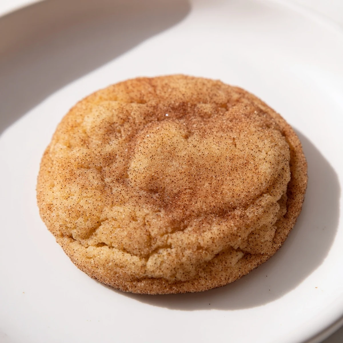 Warm, freshly baked chewy Snickerdoodle cookies sit on parchment, ready for a sweet treat.