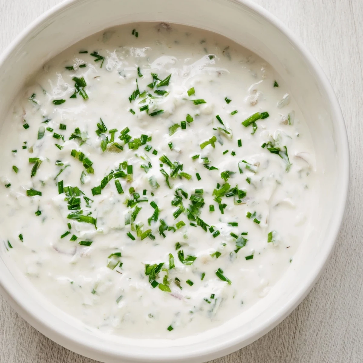 A close-up of the delicious garlic dip, ready to be scooped up with crunchy vegetables or chips.