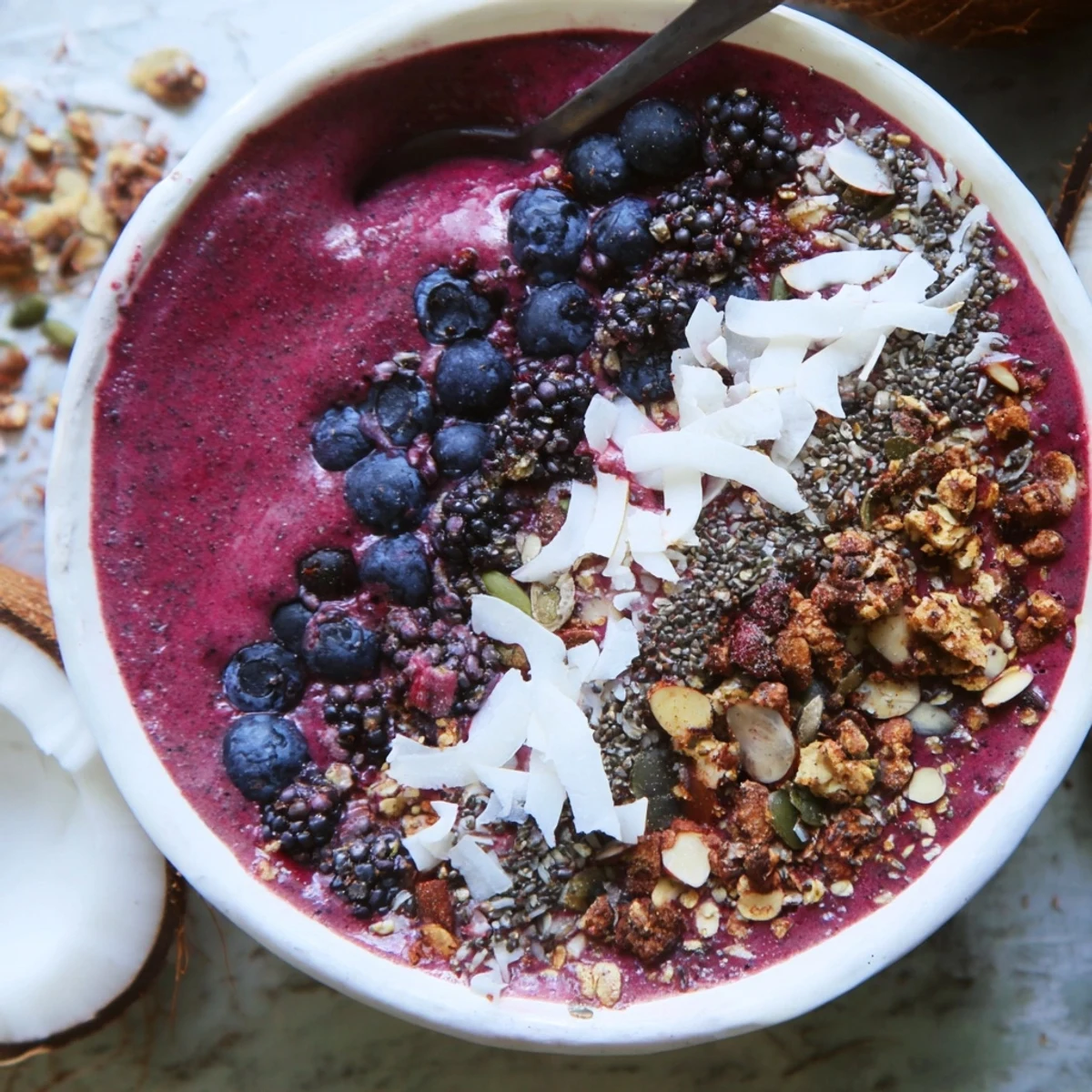 Frosted Winter Berry Smoothie Bowl topped with crunchy granola, coconut, and sliced almonds for a vibrant, energizing breakfast.