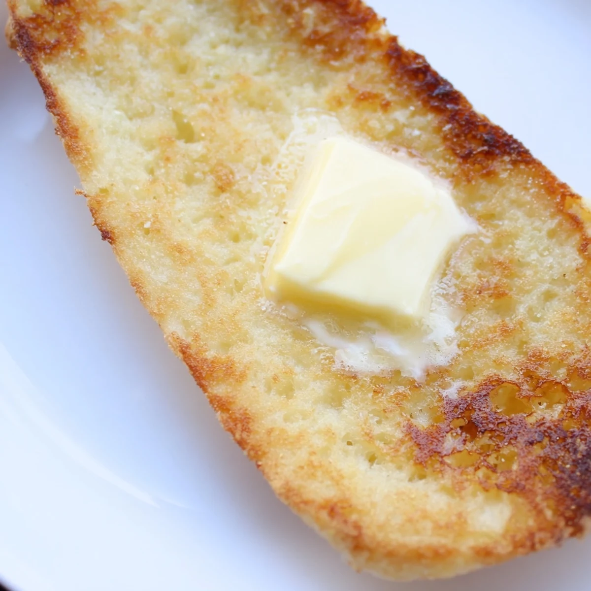 Homemade Irish Potato Bread with Butter served alongside a hearty Irish breakfast, featuring eggs and sausages on a cozy, checkered tablecloth.