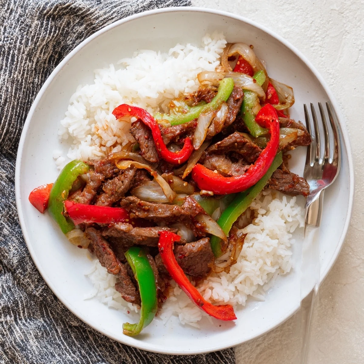 Sizzling Spicy Beef Stir-Fry with Rice, perfect for a family dinner, with a bold red chili sauce.