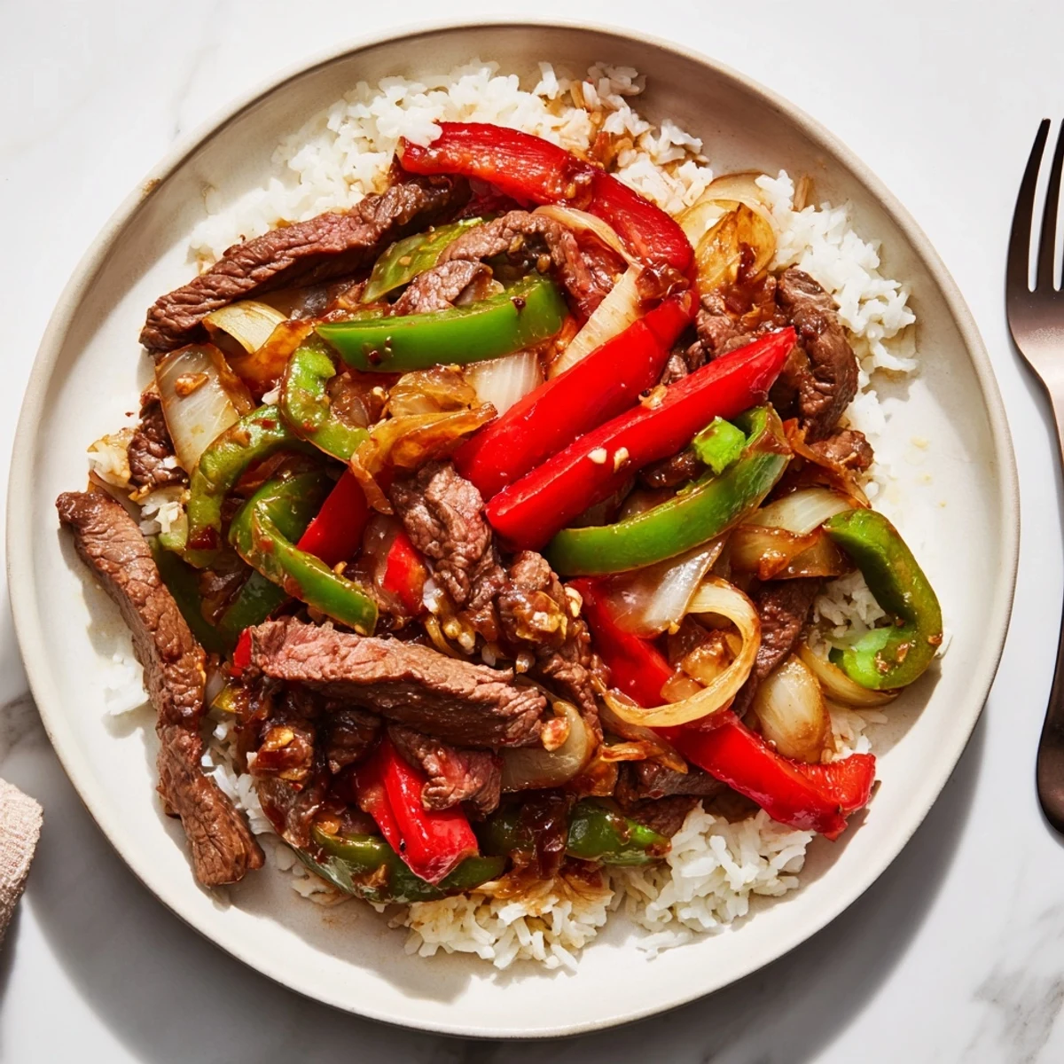 A close-up of tender beef strips, crispy vegetables, and steamed jasmine rice for Spicy Beef Stir-Fry with Rice.  