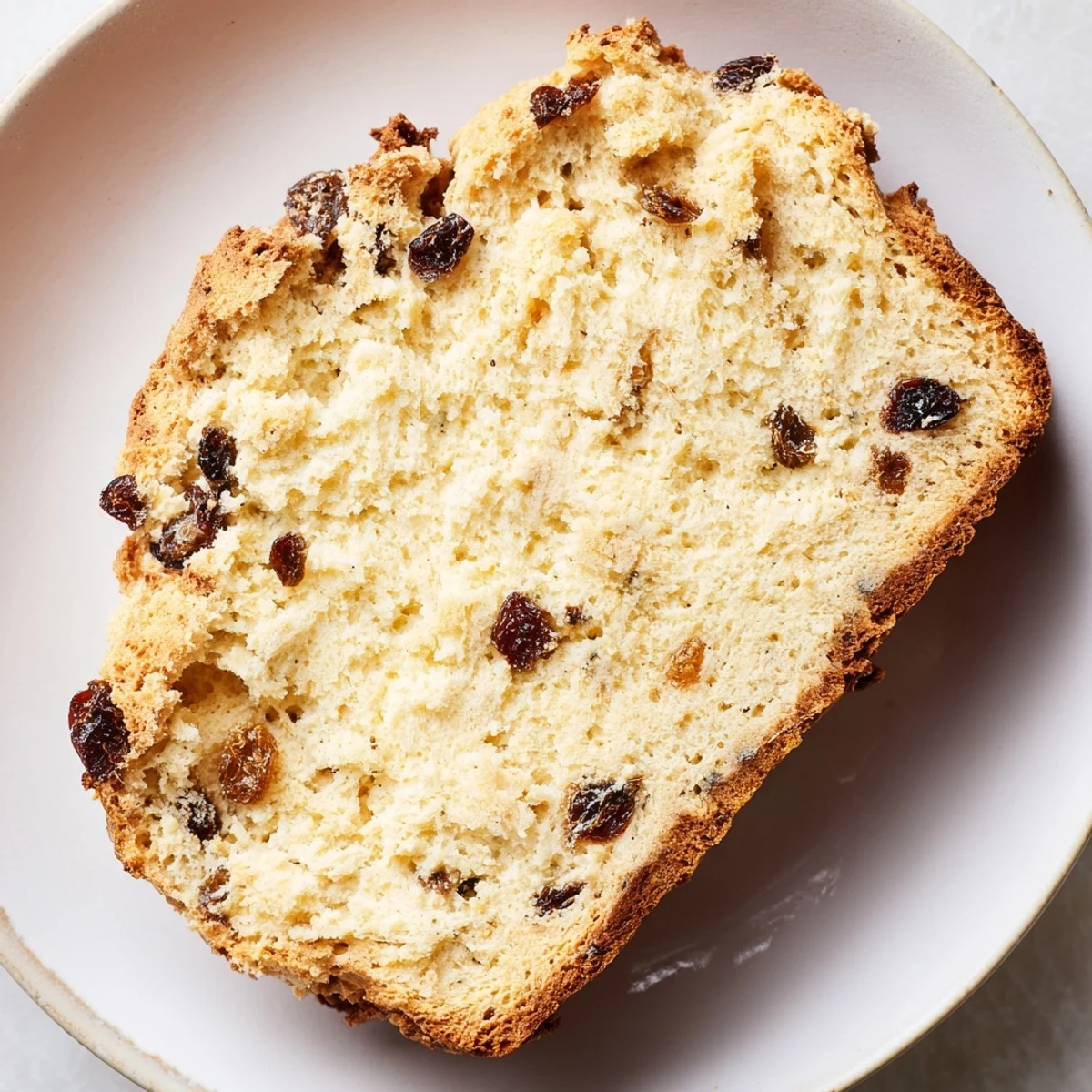 This rustic Irish Soda Bread with Currants and Caraway is sliced to reveal a tender crumb studded with sweet currants, ready to be slathered with butter.