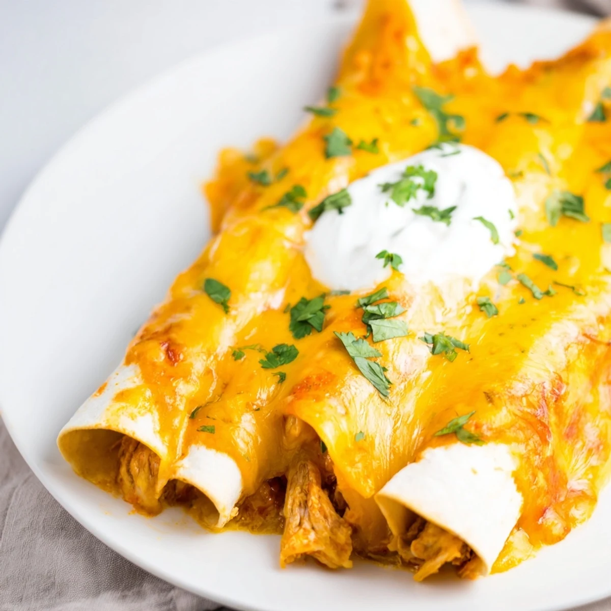 Fresh lime wedges sit beside the Beef Enchiladas with Green Sauce, highlighting the vibrant color of the sauce and the warm shredded beef filling.