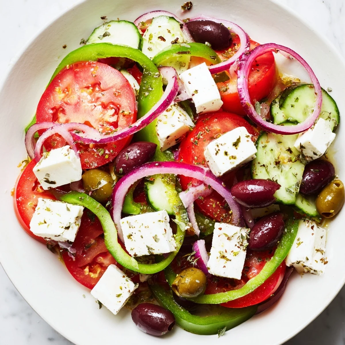 A close-up of Greek Salad with Kalamata Olives and Feta, drizzled with oregano dressing, ready to serve.  