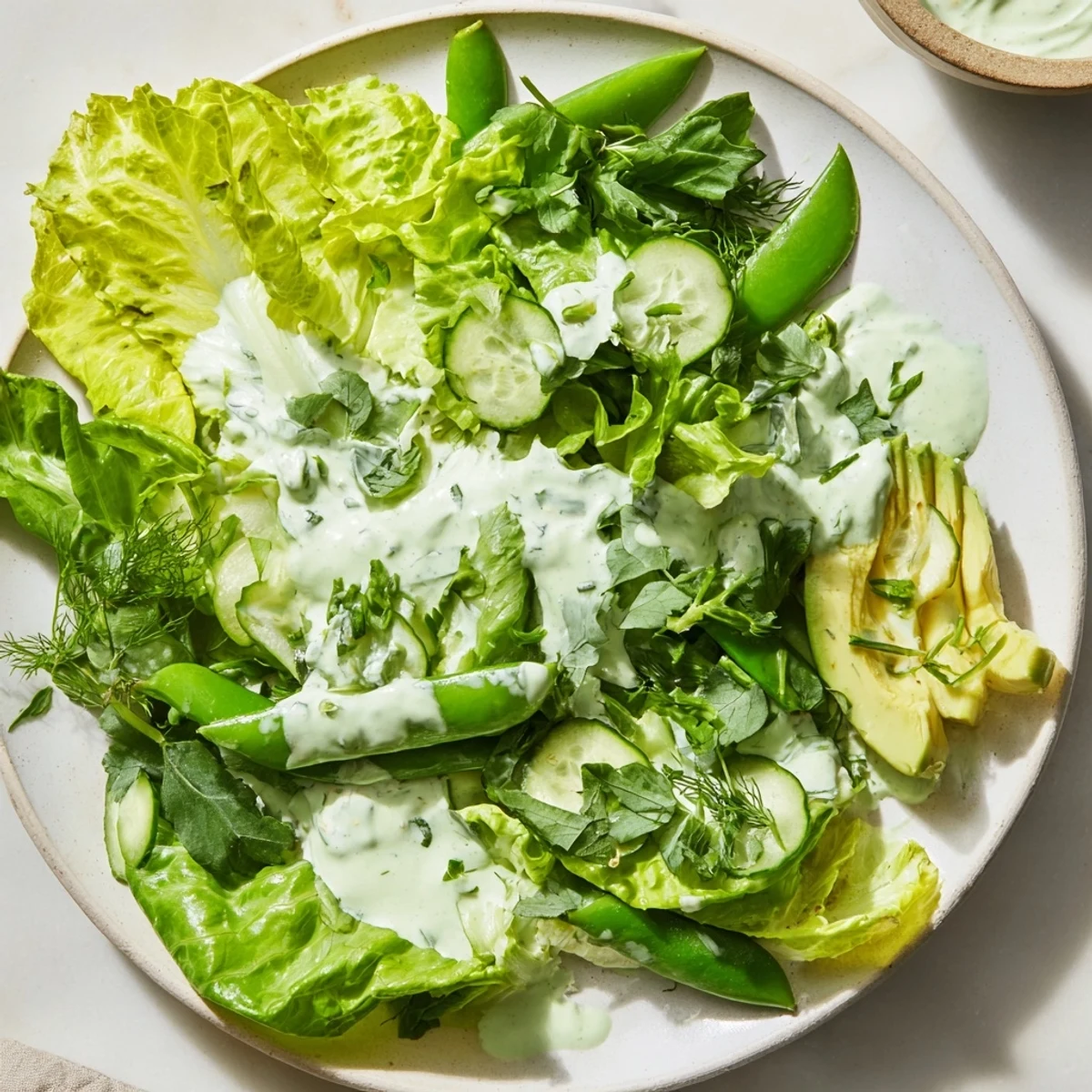 Green Salad with Green Goddess Dressing featuring crunchy cucumbers and snap peas tossed in a herby dressing.