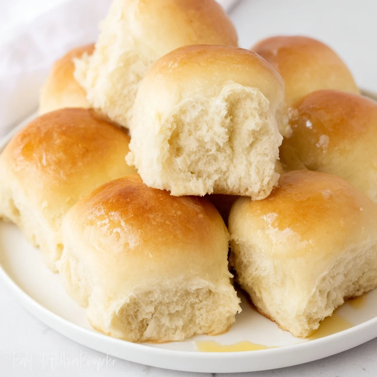 Golden-brown Best Vegan Dinner Rolls arranged in a baking dish, brushed with melted vegan butter for a soft, buttery finish.