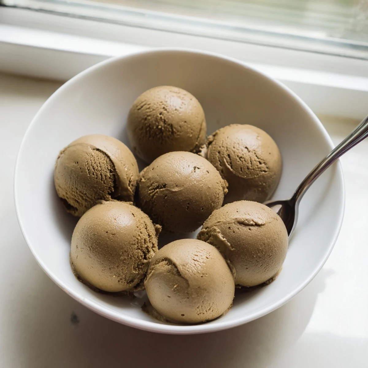 Dark, velvety Hojicha Ice Cream served in a waffle cone, perfect for a unique Japanese-inspired dessert.