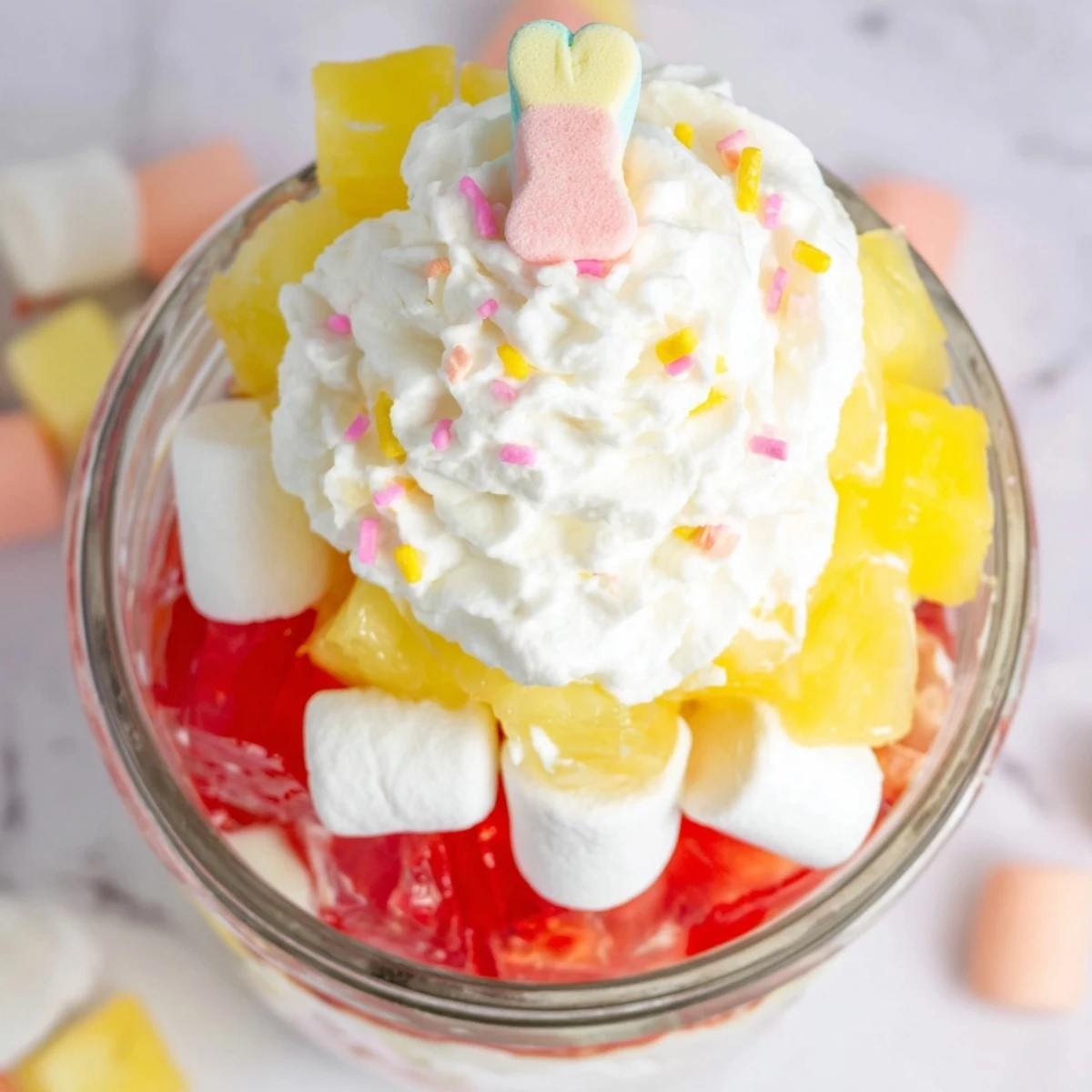 The finished Jello Pie Easter Bunny Parfait In A Jar topped with whipped cream and a pastel Easter bunny candy