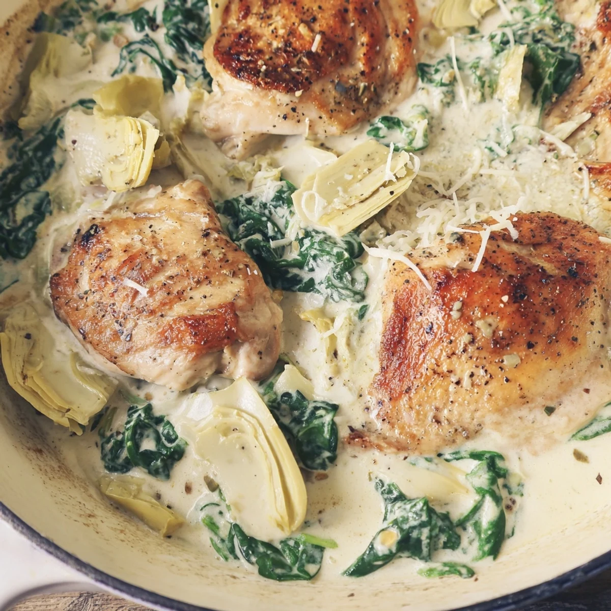 Tender chicken breasts are baked in a rich spinach and artichoke cottage cheese sauce, garnished with fresh parsley and parmesan.