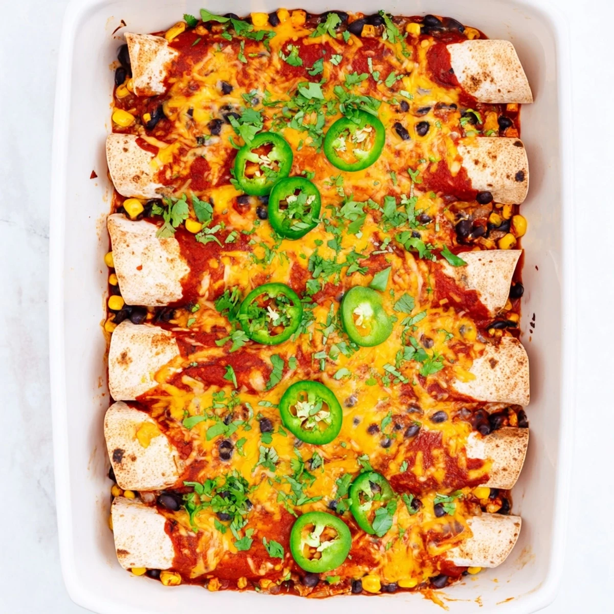 Golden-baked Chicken Enchiladas stuffed with shredded chicken, covered in red sauce and melted cheese.