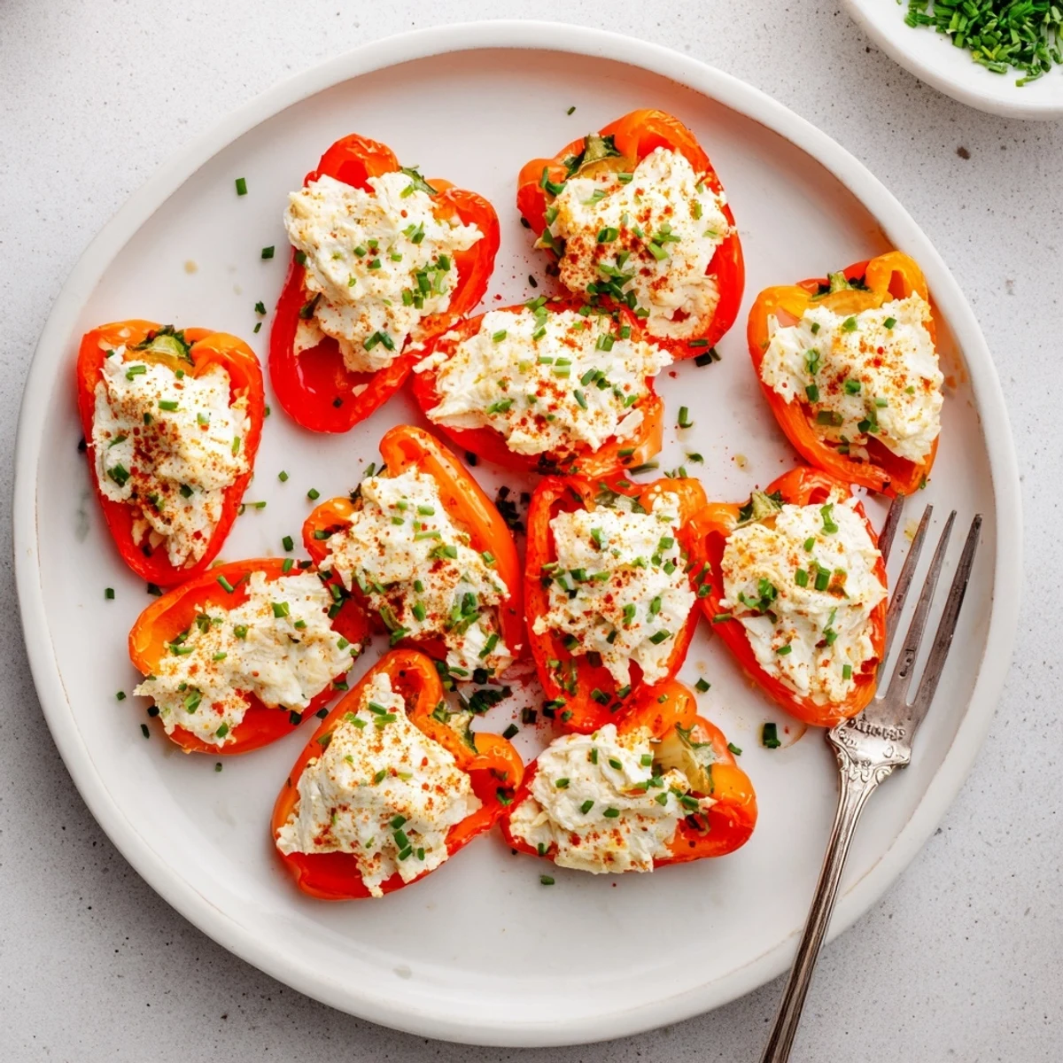Golden air fryer cream cheese stuffed mini peppers arranged on a white serving platter