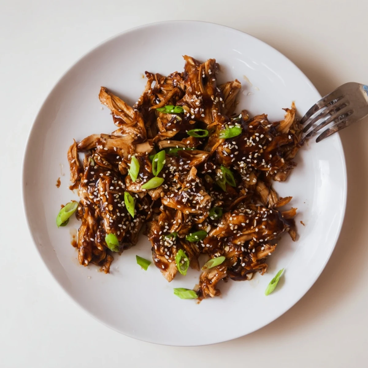 Easy slow cooker Mongolian chicken served steaming in bowls with fluffy rice and fresh scallion topping