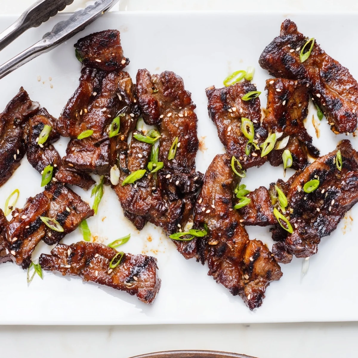 Tender beef short ribs glazed in savory Korean marinade, fresh off the grill with green onions