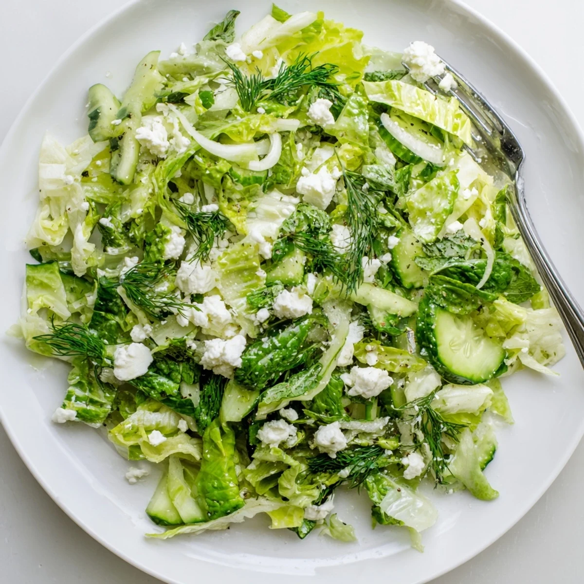Fresh Maroulosalata Greek salad with shredded romaine, dill, mint, and bright lemon dressing in a white bowl