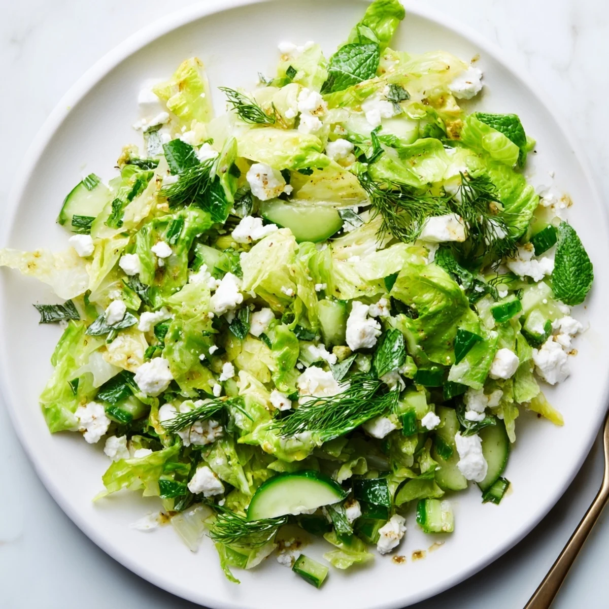 Vibrant Maroulosalata salad bowl showcasing finely chopped romaine, fresh mint, dill, and zesty lemon-olive oil emulsion
