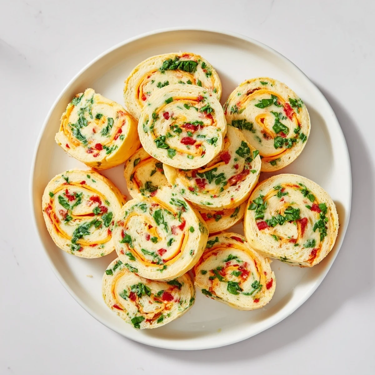 Tightly rolled tortilla pinwheels filled with creamy cheese mixture arranged on serving board for gatherings