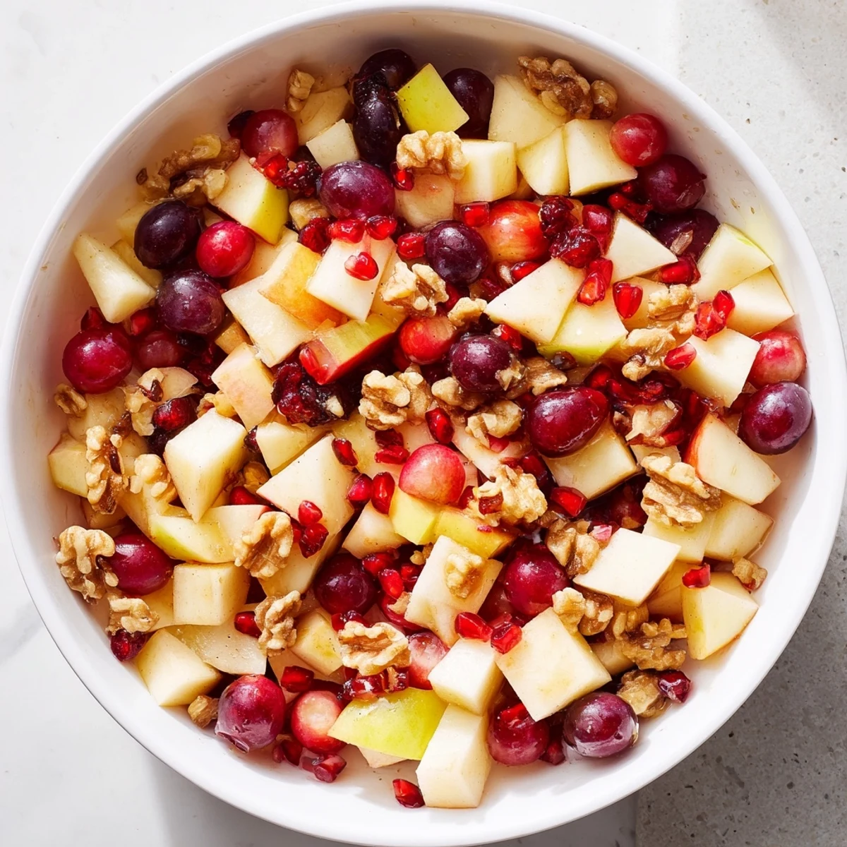 Refreshing minute fall fruit salad featuring diced apples and pears garnished with walnuts and dried cranberries