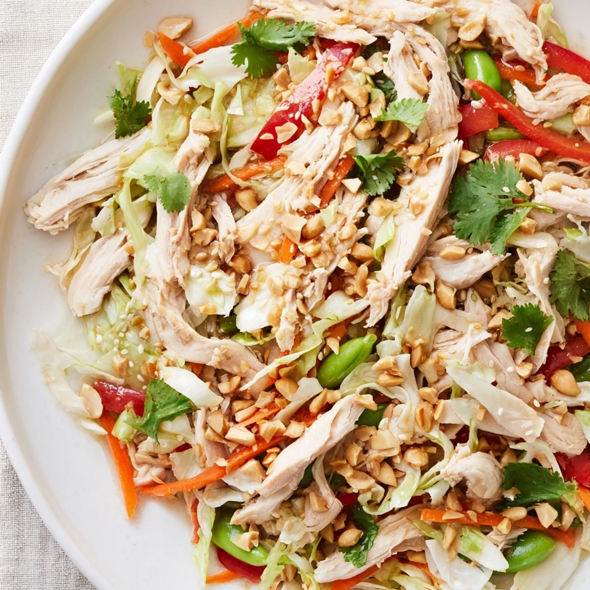 Protein-packed Asian chicken salad topped with peanuts and sesame seeds