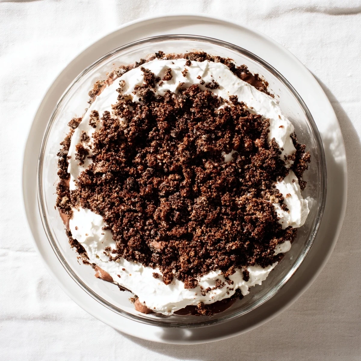 Glass trifle dish showcasing layered keto dirt cake with chocolate crumbs and creamy pudding