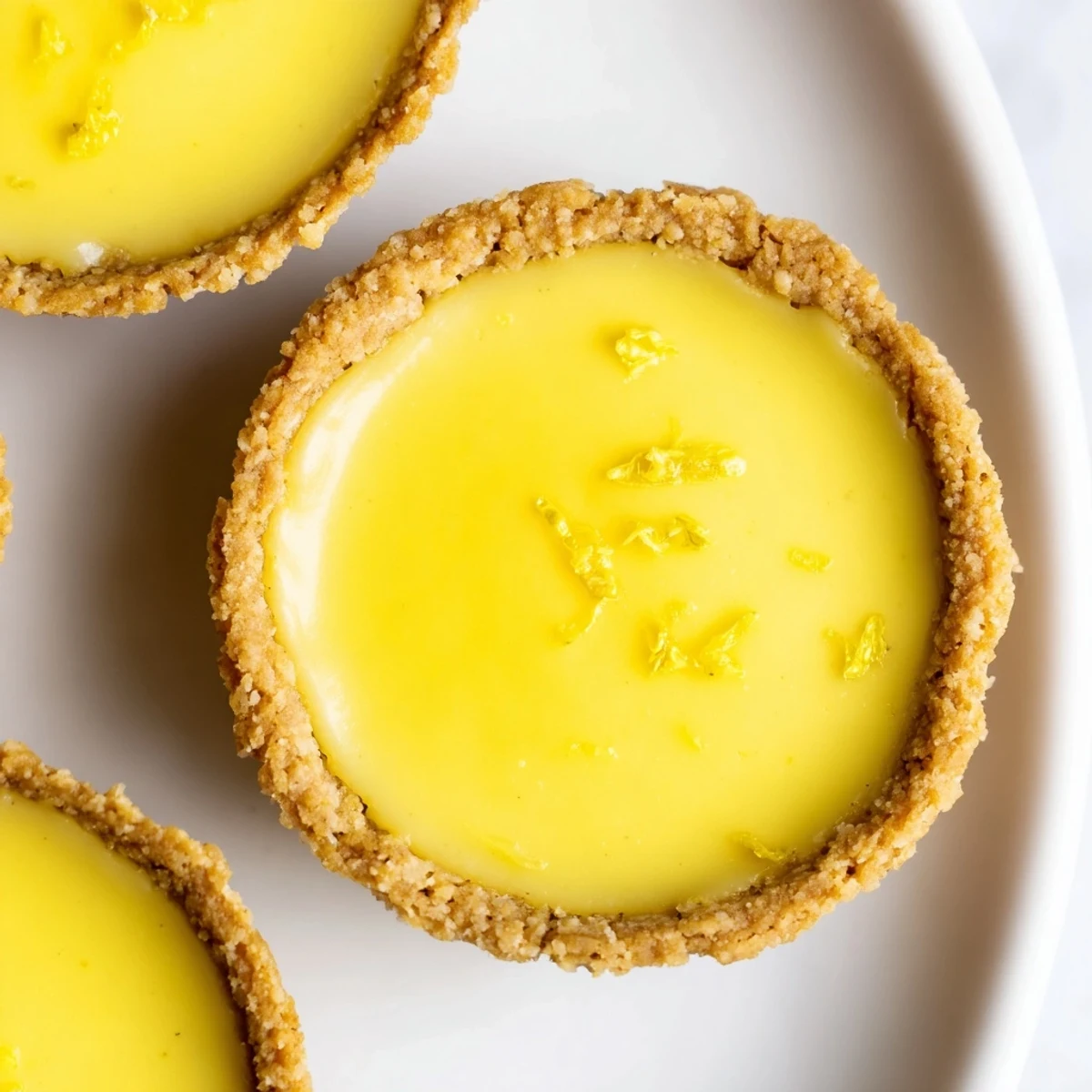 Mini vegan lemon tarts topped with fresh berries on a rustic wooden serving board