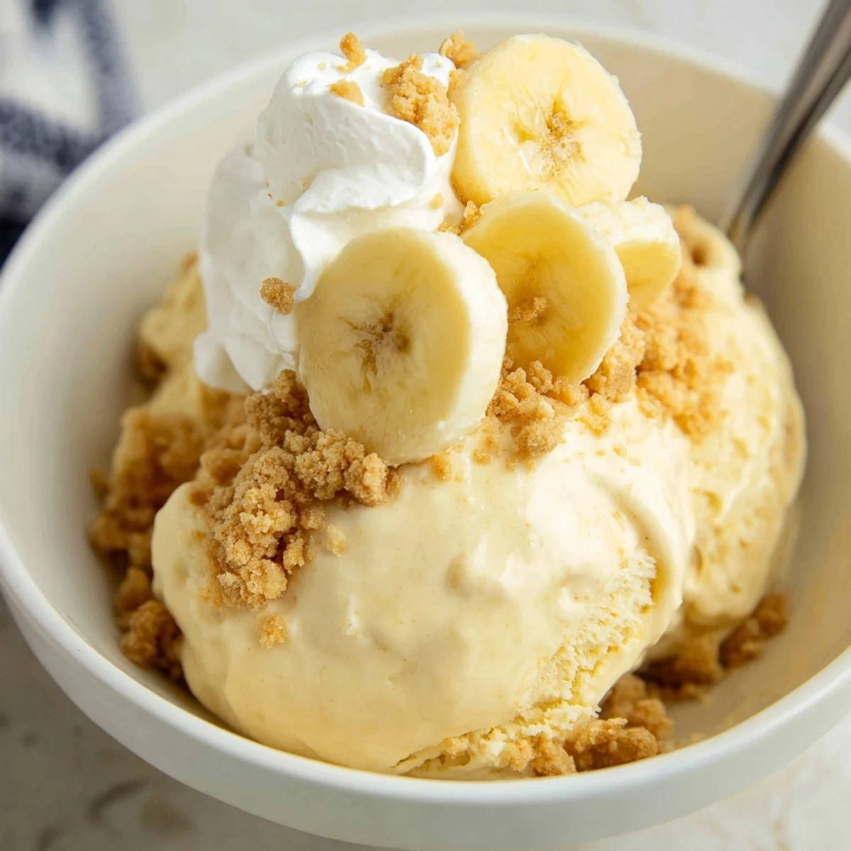 Generous scoop of Ninja Creami Banana Cream Pie Ice Cream in chilled bowls
