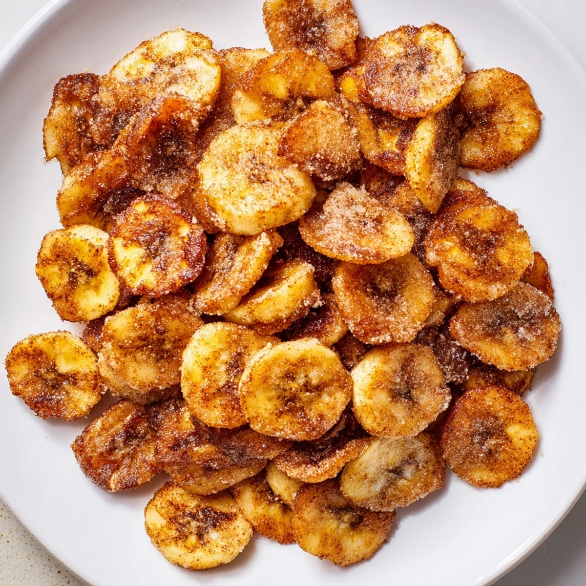 Thin, crunchy banana coins cooling on rack — Crispy Cinnamon Sugar Air Fryer Banana Chips.