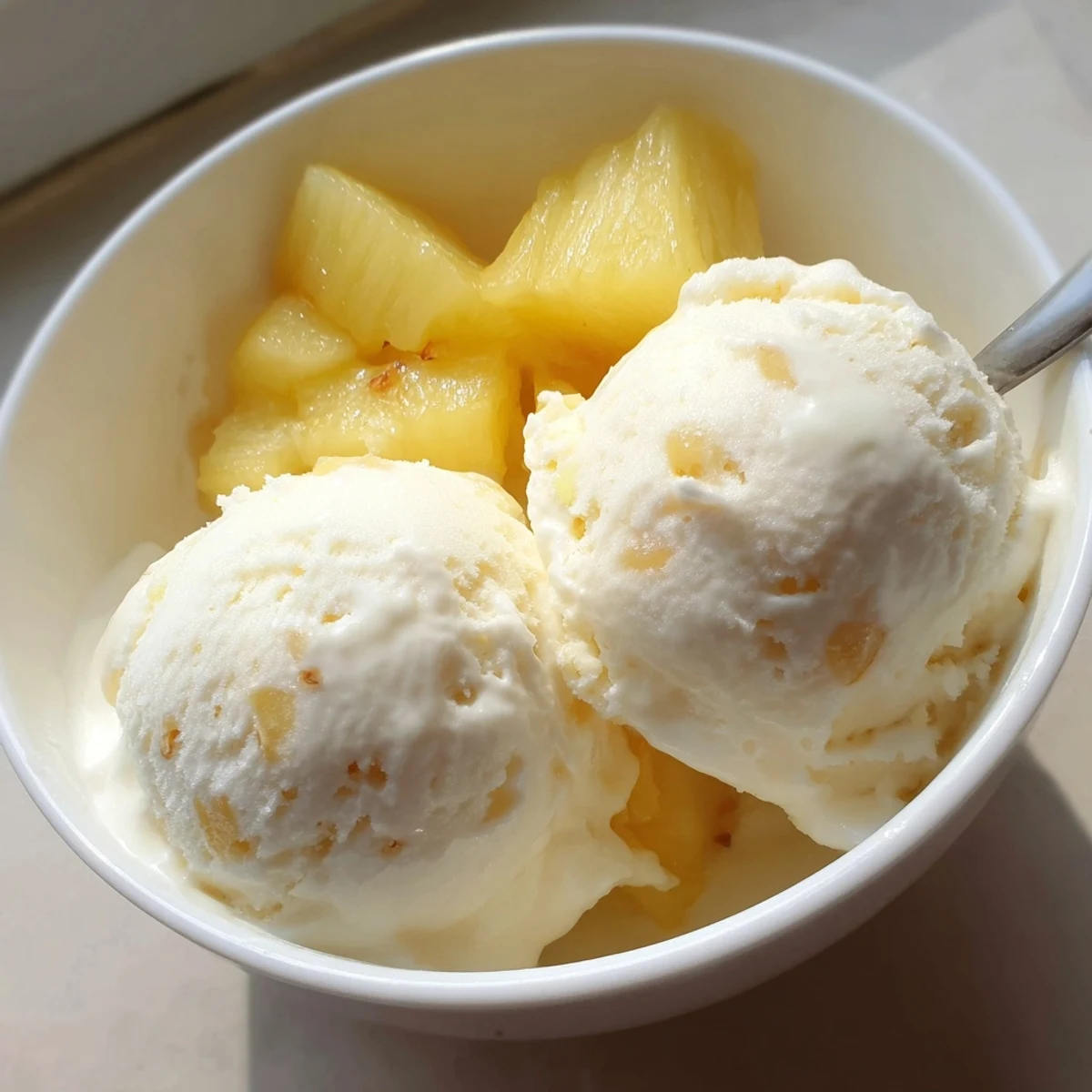 Chilled Homemade Creamy Pineapple Ice Cream topped with toasted coconut and lime