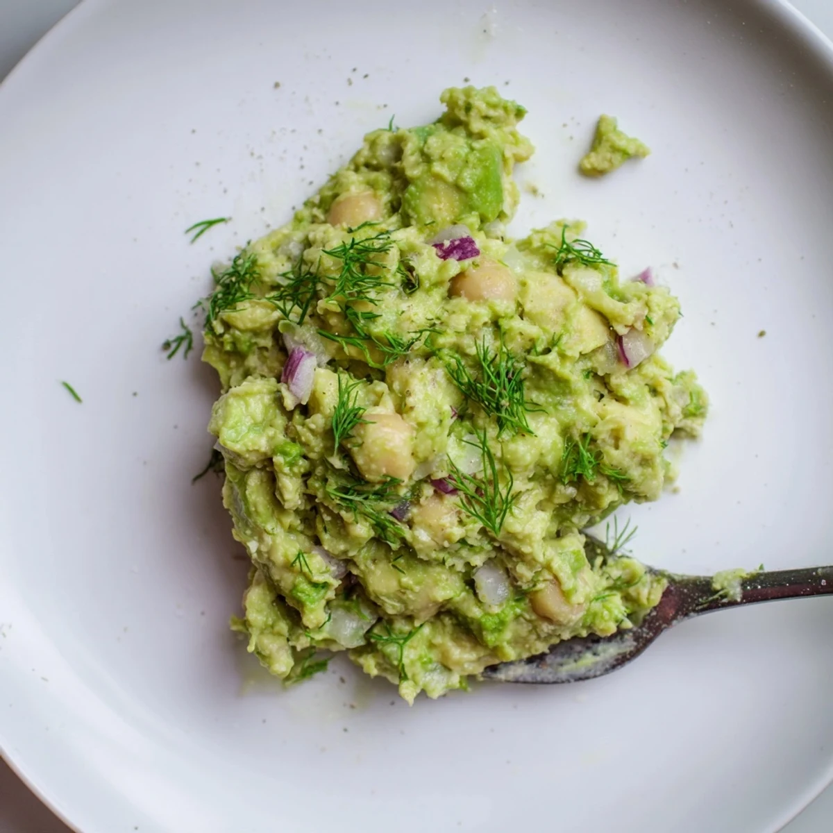 Chunky Smashed Chickpea Avocado Pickle served in bowl topped with paprika