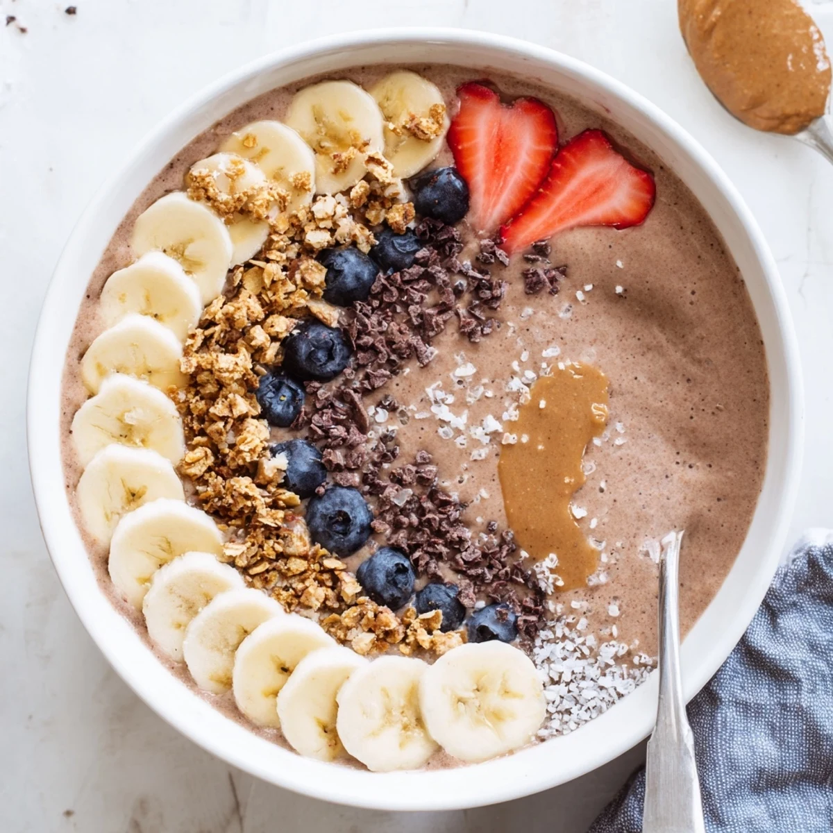 Creamy Coffee Protein Smoothie Bowl recipe topped with granola, banana, and berries