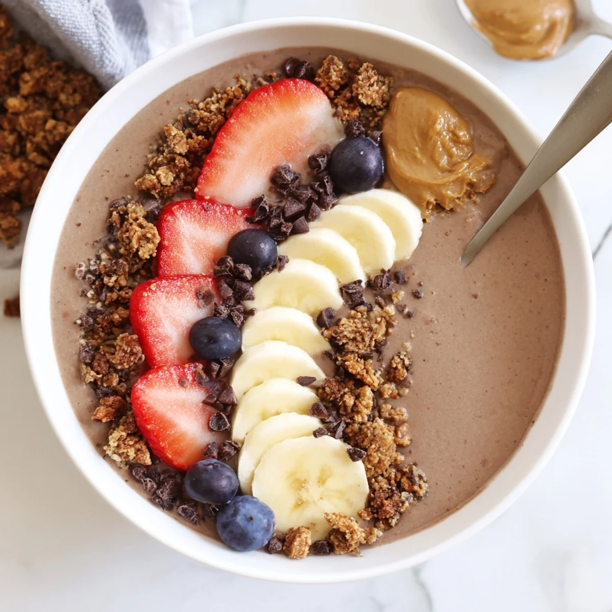 Icy, thick Coffee Protein Smoothie Bowl served with spoon, granola, and berries