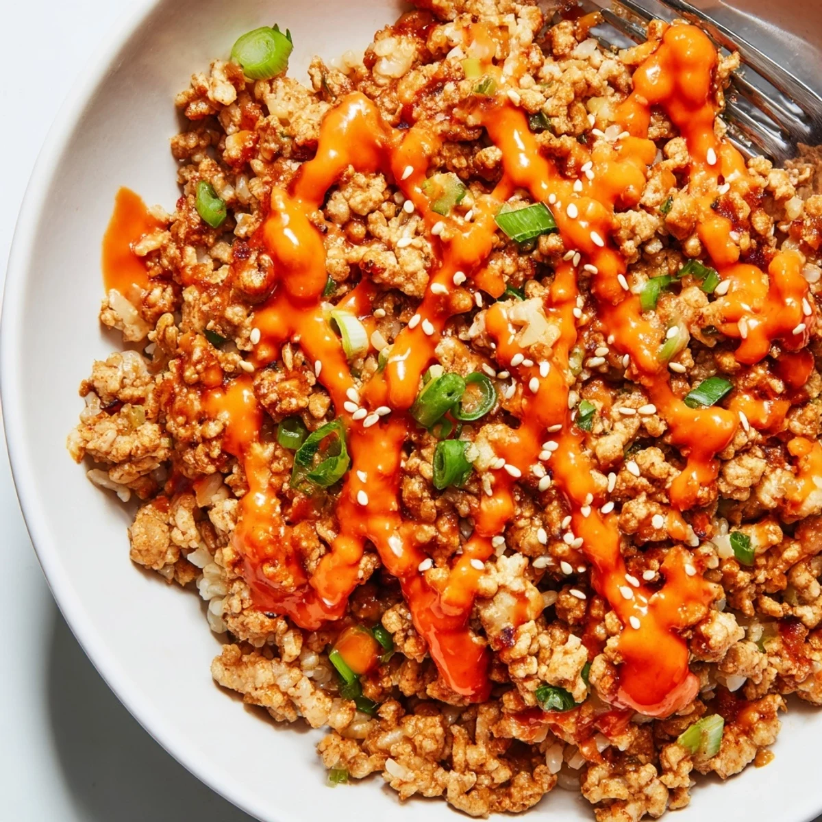 Savory seasoned Ground Turkey Rice Bowls with Bang Bang Sauce garnished with scallions and sesame seeds